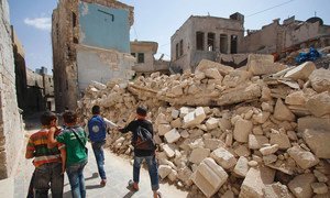 Schoolchildren in eastern Aleppo in the Syrian Arab Republic return from the first day of school, passing the rubble of nearby houses. (21 September 2016)