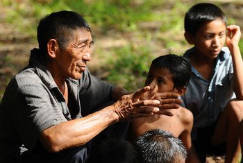 Un hombre mayor cuenta relatos a los niños según la tradición oral mapoyo.