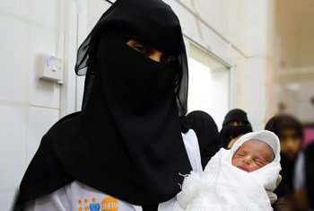 القابلة نجيبة تحمل مولودا جديدا في مرفق صحي يدعمه صندوق الأمم المتحدة للسكان في باجل، بالحديدة.
