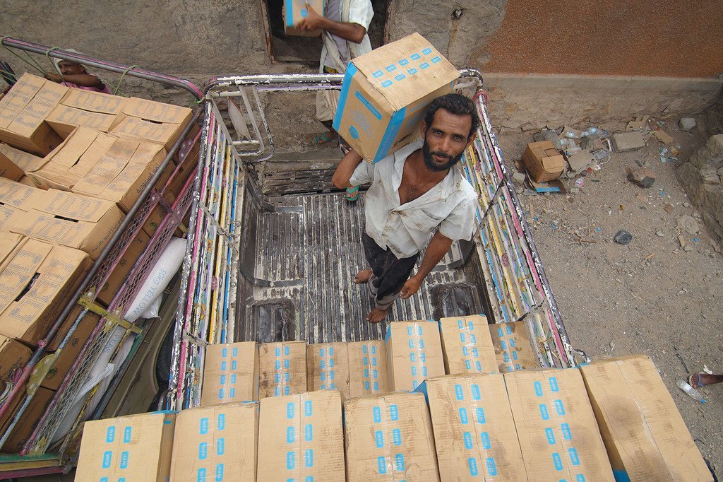 Des travailleurs empilent de l'aide alimentaire dans un entrepôt à Lahej, au Yémen, en juillet 2019.