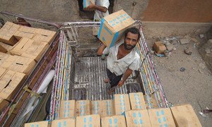 Workers stack food assistance in a warehouse in Lahj, Yemen. ( 1 July 2019)