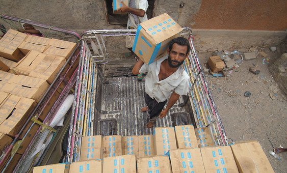 Workers stack food assistance in a warehouse in Lahj, Yemen. ( 1 July 2019)