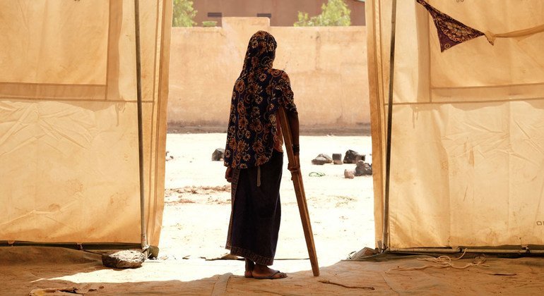 Una niña usa una muleta para caminar en un campamento de desplazados en Mali.