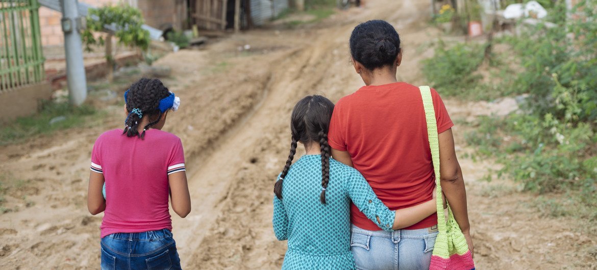 9岁的阿卡纳耶丽(中)逃离委内瑞拉的暴乱，现在与她的母亲和妹妹住在哥伦比亚。