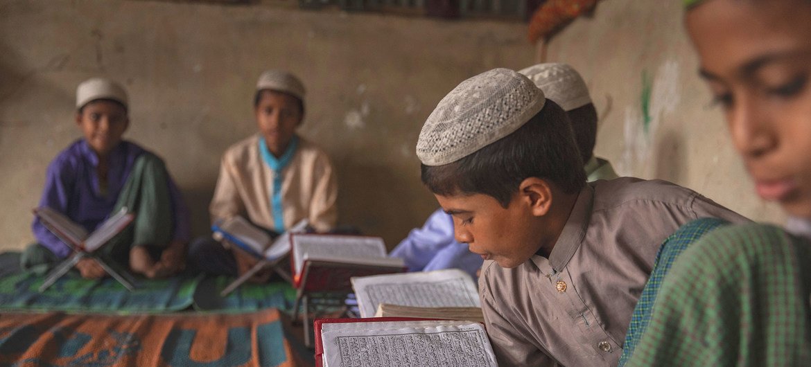 A boy reads from his textbook in a camp in Cox's Bazar, Bangladesh. (2 July 2019)