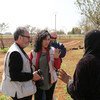 تتحدث مروة عوض، المتحدثة باسم WFP، مع امرأة في حقل خلال رحلة ميدانية في سوريا.