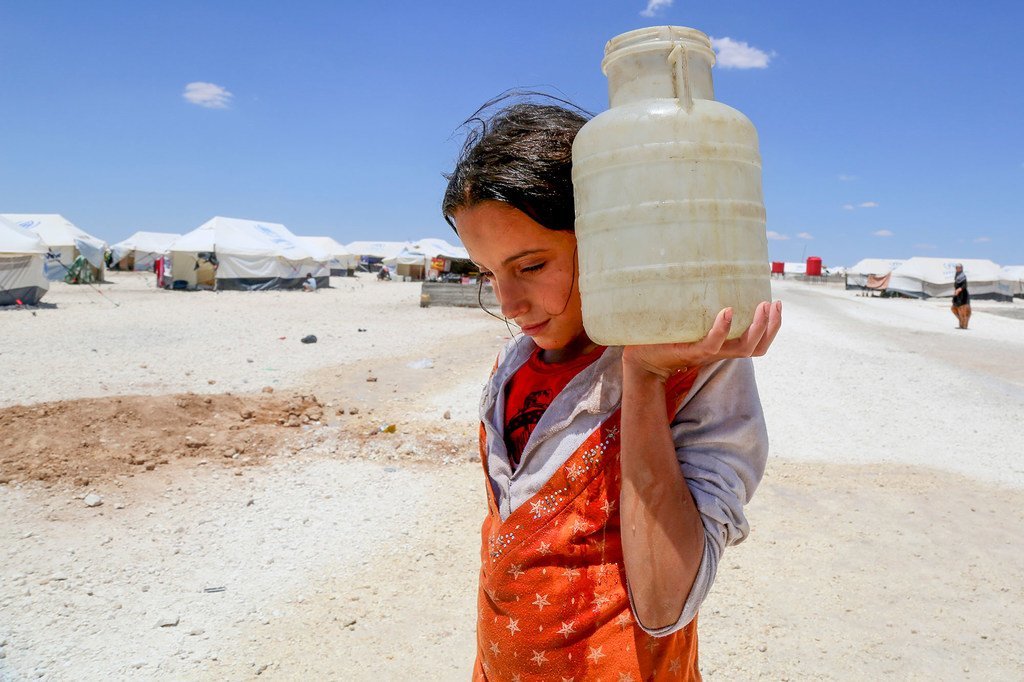 Dans un camp de fortune à Ain Issa, en Syrie, une jeune fille porte de l'eau (photo d'archives).