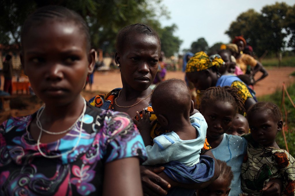 Des femmes et enfants déplacées par les violences en République centrafricaine font la queue pour se faire soigner dans un dispensaire soutenu par l'UNICEF.