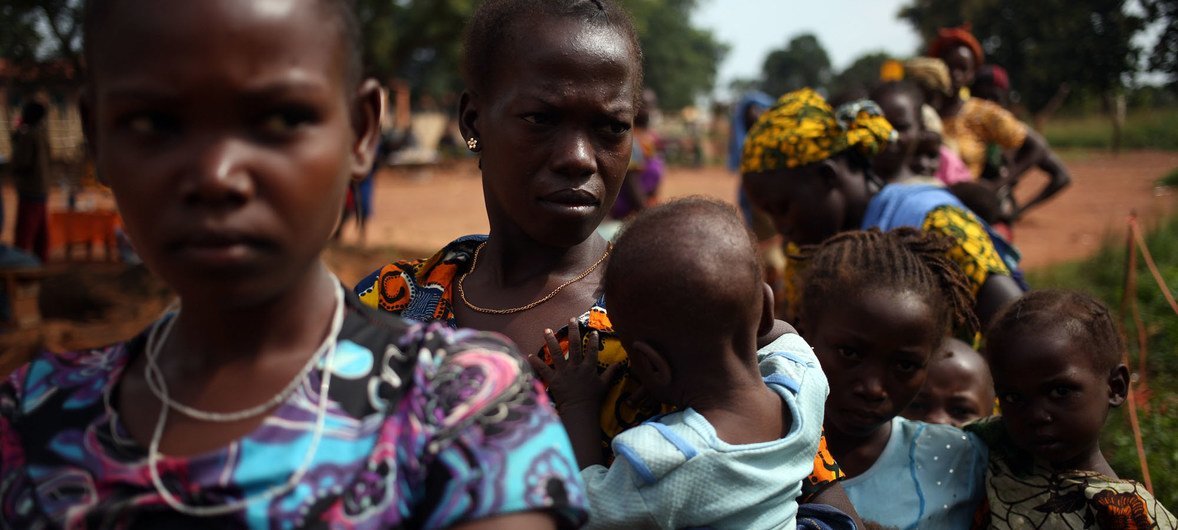 نساء هاربات من العنف في جمهورية أفريقيا الوسطى يقفن في طابور بصحبة أطفالهن لتلقي العلاج أمام عيادة طبية تدعمها اليونيسف.