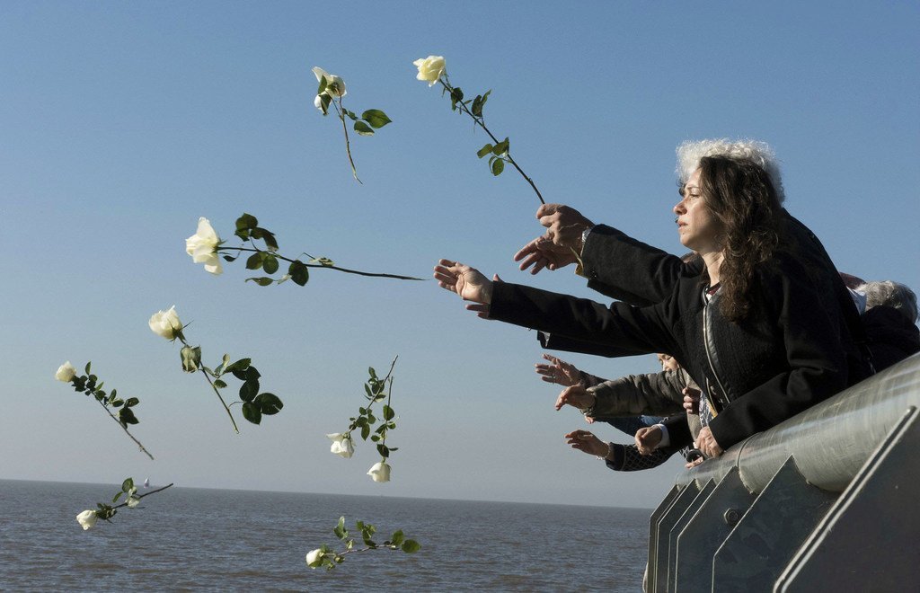 在布宜诺斯艾利斯一个纪念阿根廷军事独裁期间受害者的公园，游客将白色的花朵扔进拉普拉塔河，对缅怀那些受害作。