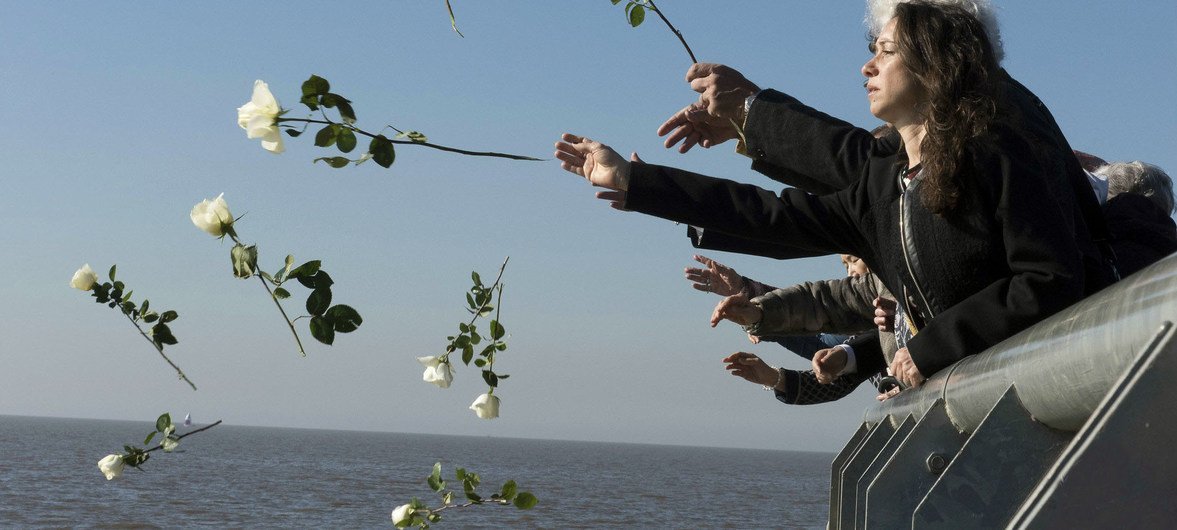 Visitors throw white flowers into Rio de la Plata in Buenos Aires out of respect and remembrance for the tens of thousands of people who disappeared during Argentina's so-called "Dirty War".