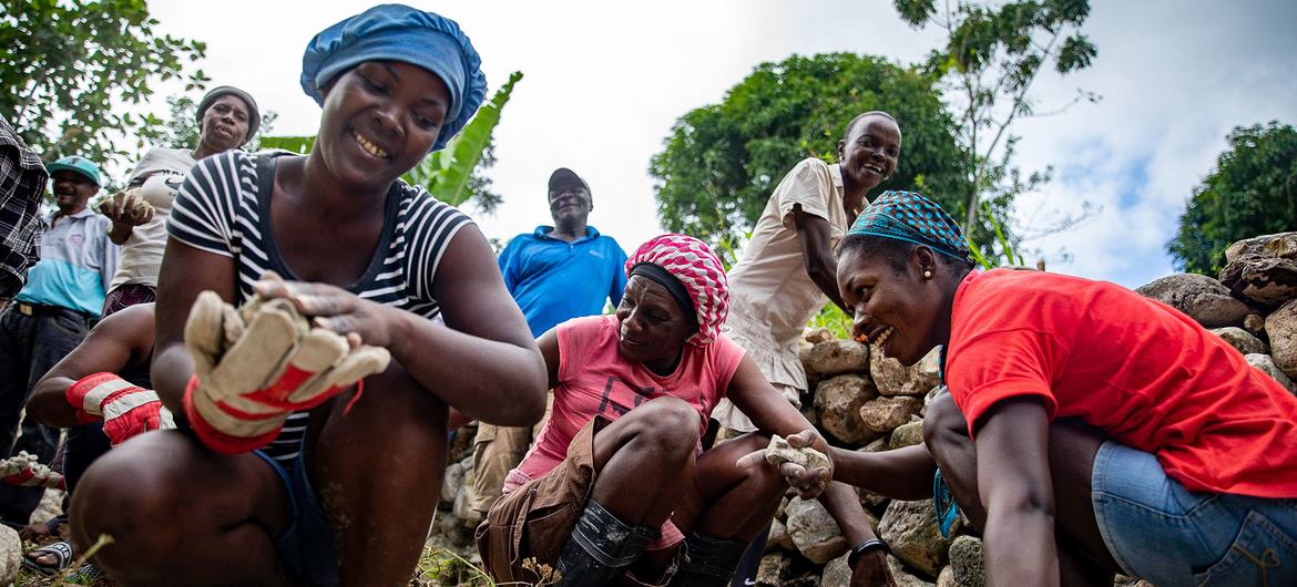 Des femmes participent à un effort communautaire pour réhabiliter des routes endommagées par le séisme d'août 2021 dans le sud-ouest d'Haïti.