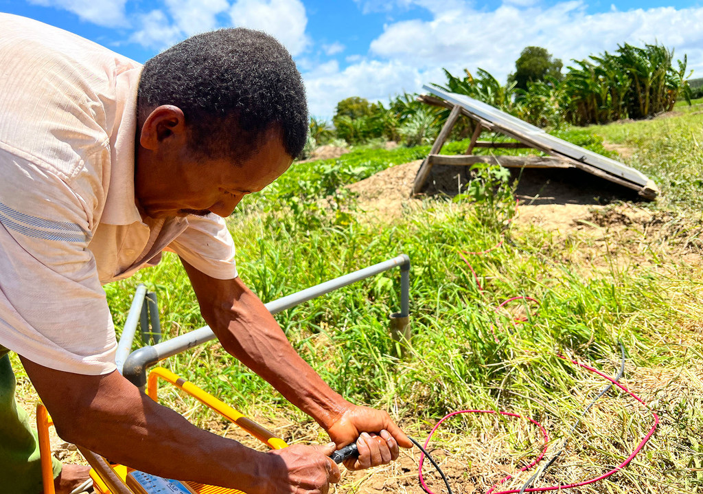 马达加斯加的一位农民在连接太阳能水泵，以便灌溉庄稼。