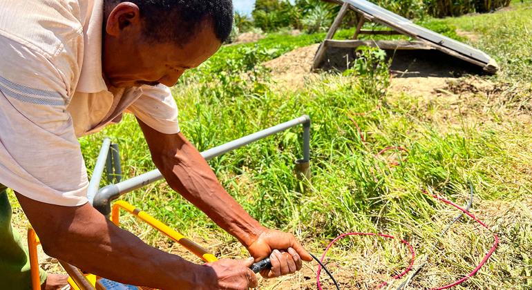 Un agricultor de Madagascar conecta una bomba alimentada por energía solar para regar sus cultivos.