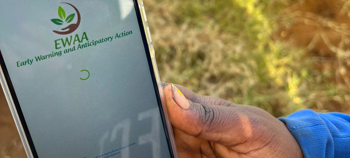 A farmer in Madagascar shows an app which helps him to prepare for the onset of extreme weather patterns.
