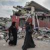 在加沙，妇女走在被摧毁的街道上。
