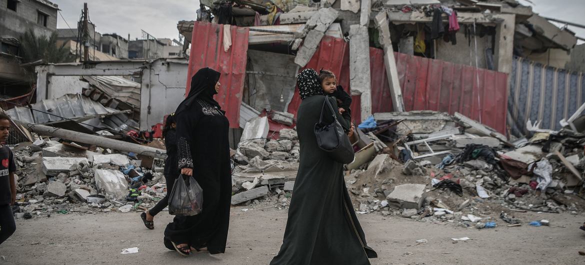 Mulheres caminham pelas ruas destruídas em Gaza