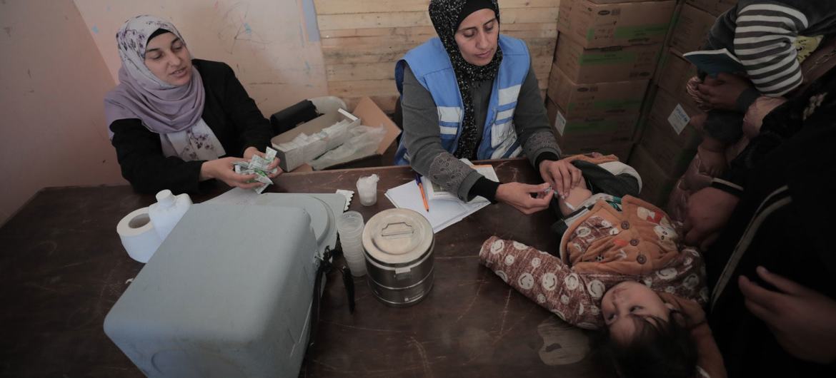 An UNRWA staff member provides medical care to a child in Gaza. (file)