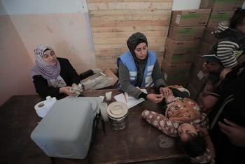 An UNRWA staff member provides medical care to a child in Gaza. (file)