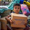 Um menino em Myanmar segura uma caixa de suprimentos de água, saneamento e higiene da Unicef após um terremoto.