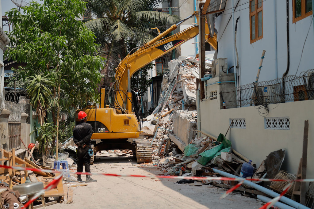 Спасатели пытаются найти выживших в разрушенном здании после землетрясения в Мандалае.