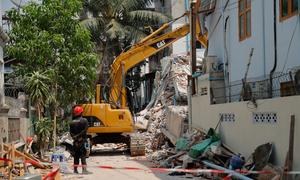 Rescue workers attempt to find people in a destroyed building after the earthquake in Mandalay. (March 2025)