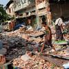 Sobreviventes do terremoto examinam as ruínas de suas casas em Pyinmana, Mianmar, após o terremoto ocorrido lá