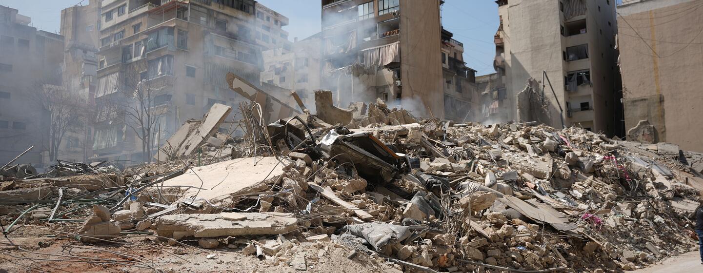 Une rue dans le quartier Bashura de Beyrouth, au Liban, recouverte de décombres et de débris provenant de bâtiments détruits à la suite de frappes aériennes, avec de la fumée provenant des débris.