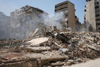 黎巴嫩贝鲁特巴沙拉区的一条街道,在空袭后被毁建筑物的瓦和碎片覆盖,烟雾从残骸上升.