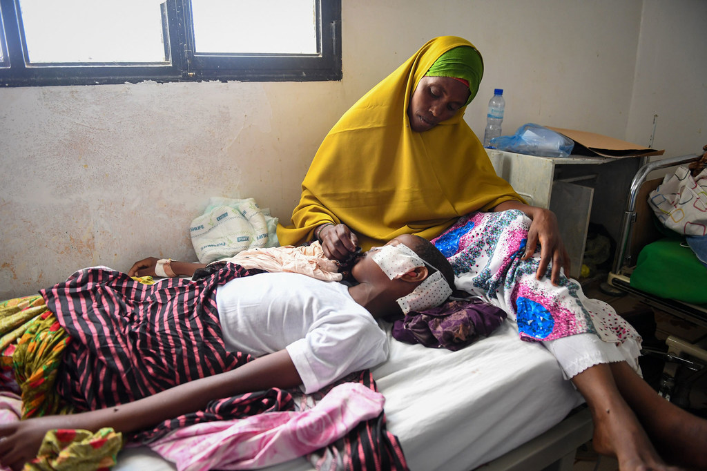 Mama akimtunza mtoto wake mwenye umri wa miaka 11, ambaye alijeruhiwa na makombora katika shambulio la mabomu, katika hospitali kuu ya Garowe, Somalia mnamo tarehe 27 Februari 2023. (Maktaba)