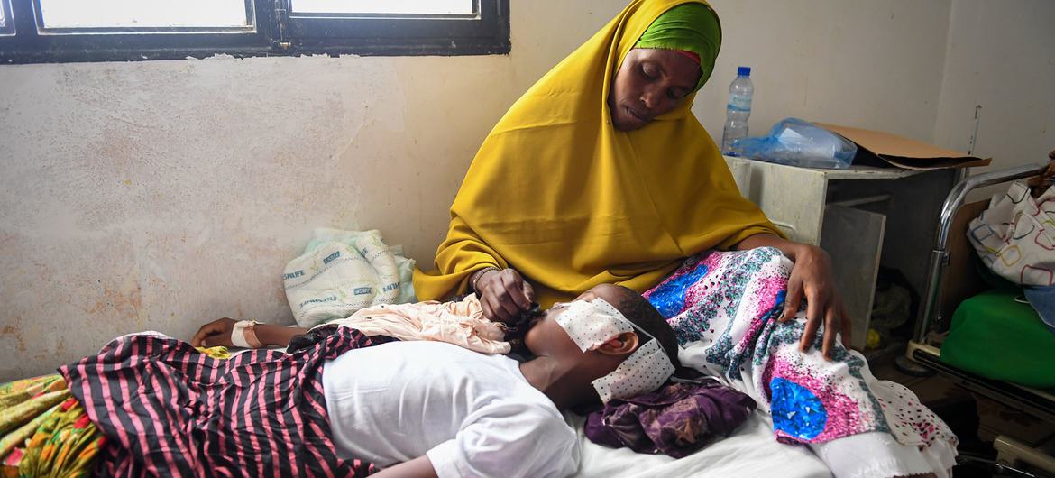 من الأرشيف: أم ترعى طفلها البالغ من العمر 11 عاما، والذي أصيب بشظية في هجوم بقذائف الهاون، في المستشفى العام في غاروي بالصومال.