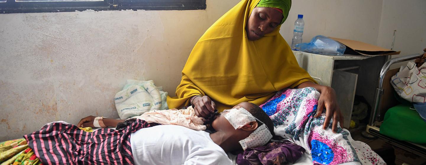 A mother caring for her 11-year-old child, who was wounded by shrapnel in a mortar attack, at the General Hospital in Garowe, Somalia on 27 February 2023.