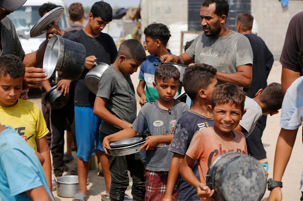 Children queue for food in Gaza.