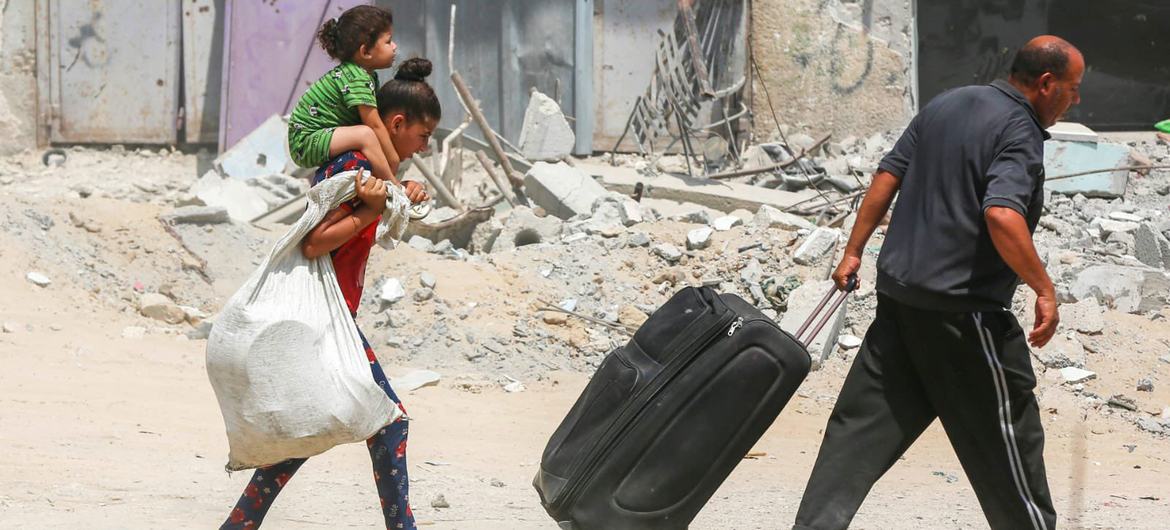 A family moves possessions amidst the rubble in Gaza (file).