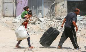 A family moves possessions amidst the rubble in Gaza (file).