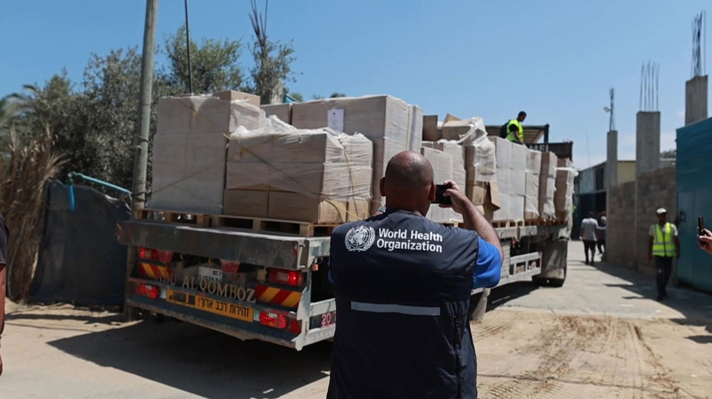 Afisa wa Shirika la Afya Duniani anaandika kuhusu kuwasili kwa vifaa vya matibabu kwenye lori katika ghala huko Deir al Balah, Gaza.