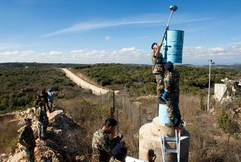 أرشيف: ضباط من اليونيفيل والجيش اللبناني يديرون أحد "البراميل الزرقاء" التي تحدد الخط الأزرق في جنوب لبنان في عام 2010.