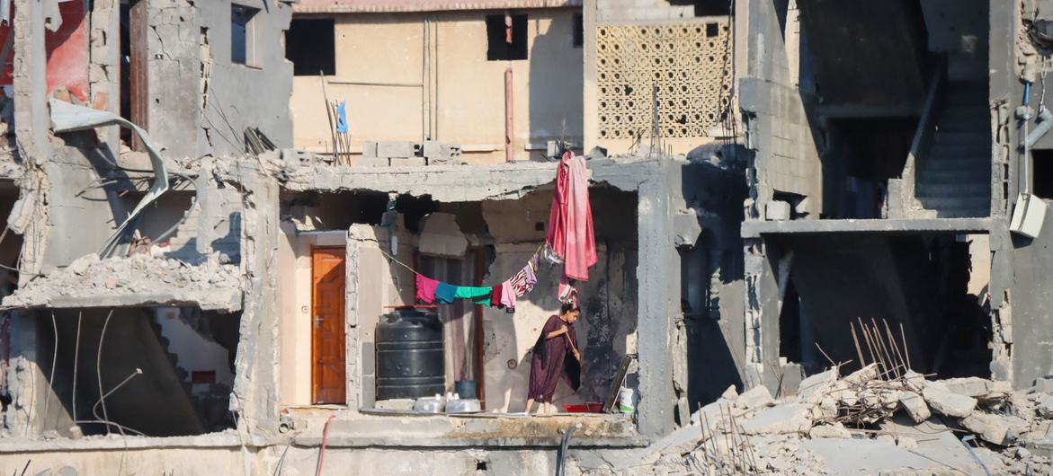 Une femme nettoie le sol d'un bâtiment détruit à Gaza.