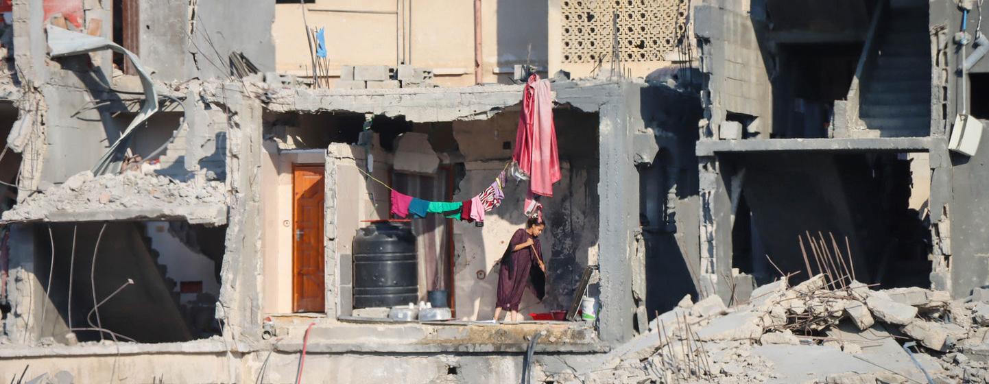 A woman cleans the floor of a destroyed building in Gaza.