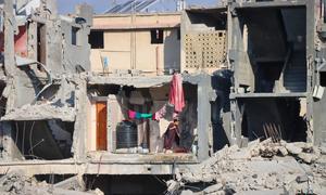 A woman cleans the floor of a destroyed building in Gaza.