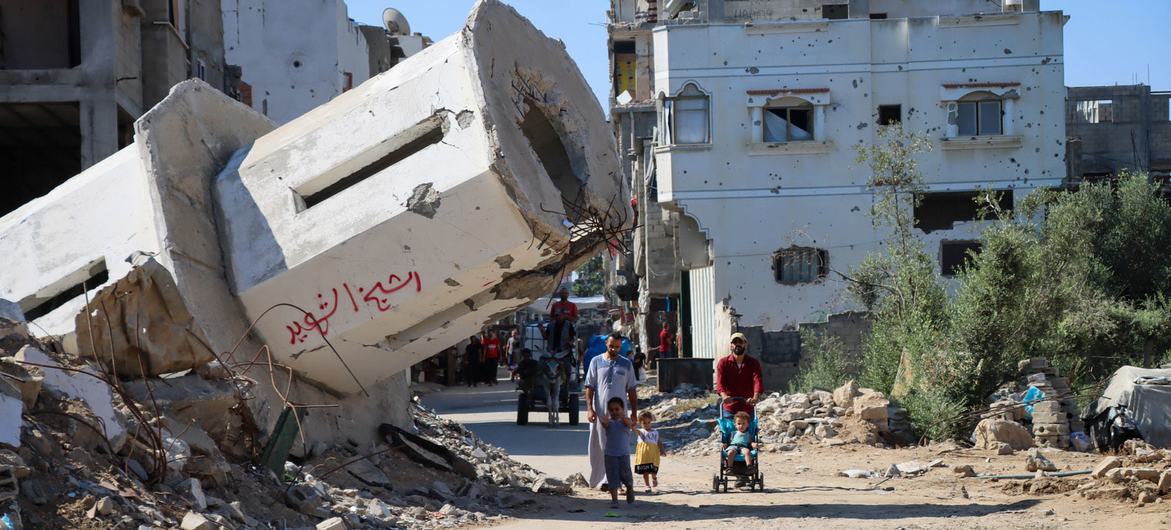 Una familia pasa frente a una mezquita destruida en Gaza.