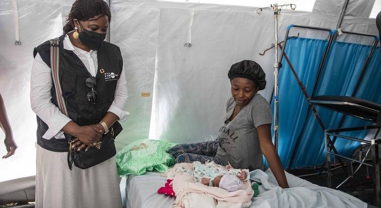 Deputy Executive Director of UNFPA, Diene Keita (left), talks to the mother of a newborn baby.