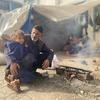 Un hombre y un niño sentados junto a una pequeña hoguera en Nuseirat, en el centro de Gaza.