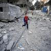 Un garçon court dans les rues détruites de Gaza.