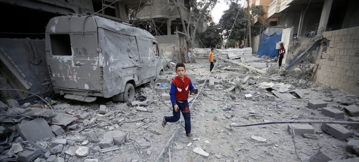 Puer per plateas Gazae destructas decurrit.