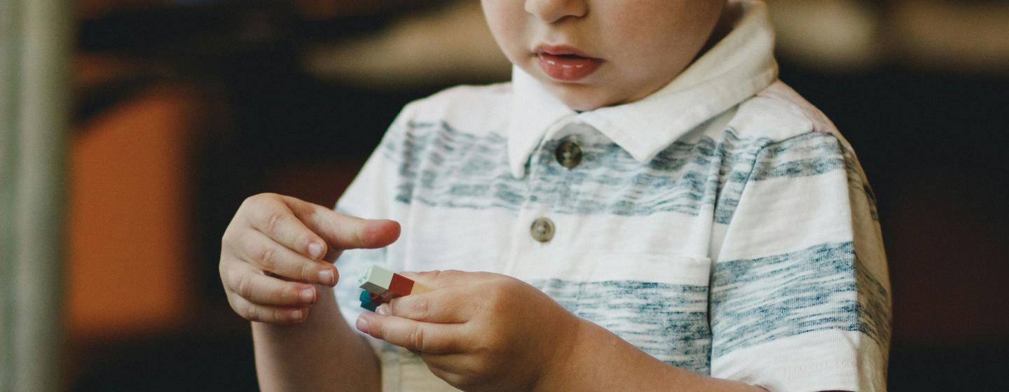 Un garçon autiste joue avec des blocs de construction.
