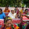 Mulheres em Odisha seguram cartazes com a hashtag '#DigaNãoAoCasamentoInfantil' durante uma reunião do Fórum de Líderes Tradicionais na vila de Rangipur, abordando a proibição do casamento infantil.