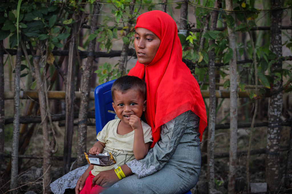 A Rohingya refugee rests with a child after being rescued at sea off the coast of Indonesia.