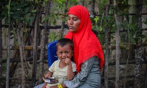 A Rohingya refugee rests with a child after being rescued at sea off the coast of Indonesia.