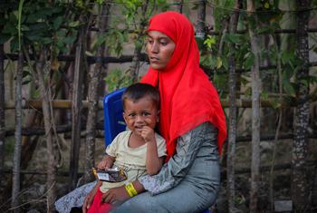 A Rohingya refugee rests with a child after being rescued at sea off the coast of Indonesia.
